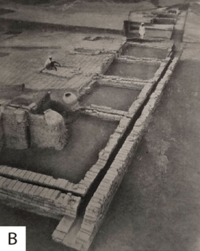 photographie ancienne de fouilles archéologiques. On y voit un système de caniveaux construits en pierres positionnées comme des briques, qui autrefois reliaient les habitations au réseau de la cité.